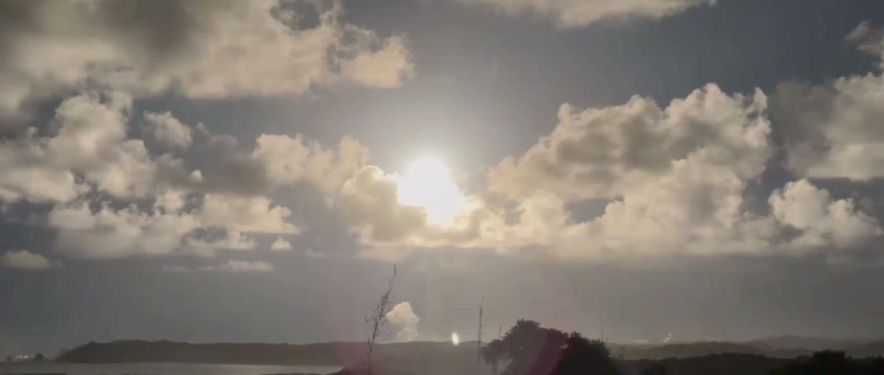 種子島宇宙センター周辺から撮影したH3ロケット9号機の打上げ。雲を貫く光柱が夜明け前の海と岬を照らしている